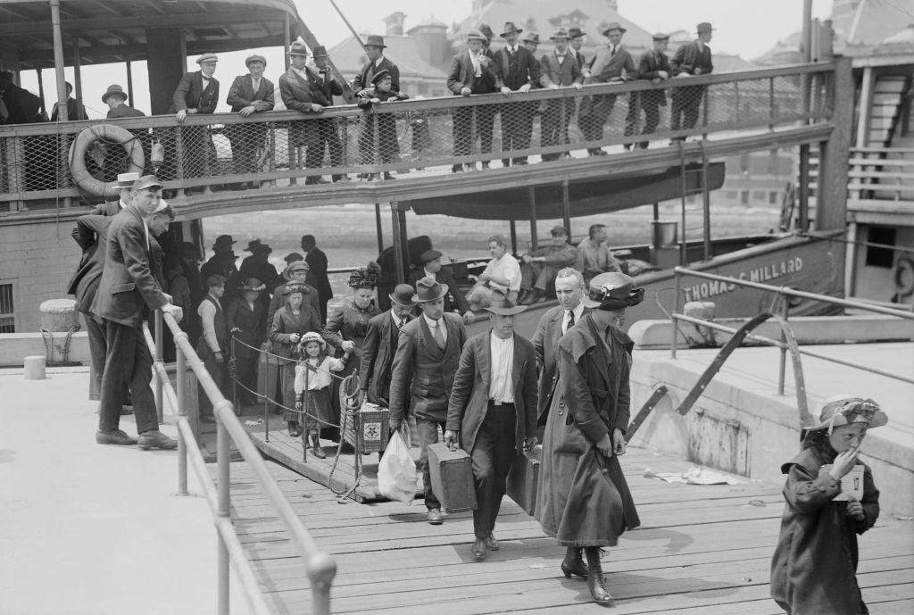 Outside a shipyard, a ship is docked with some men, women, and children walking out carrying bags while others are standing on the ship's edge, looking at people leaving.