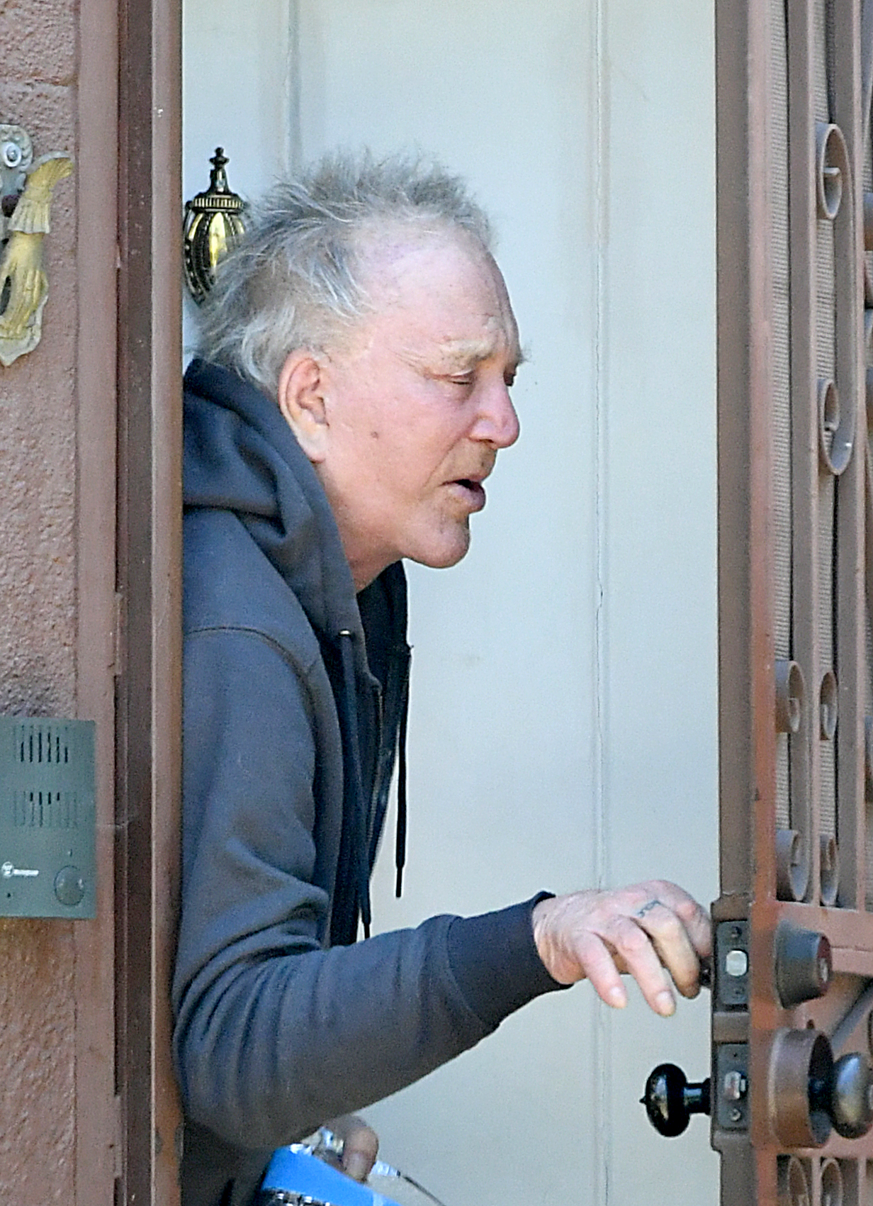 Mickey Rourke opens a door. 