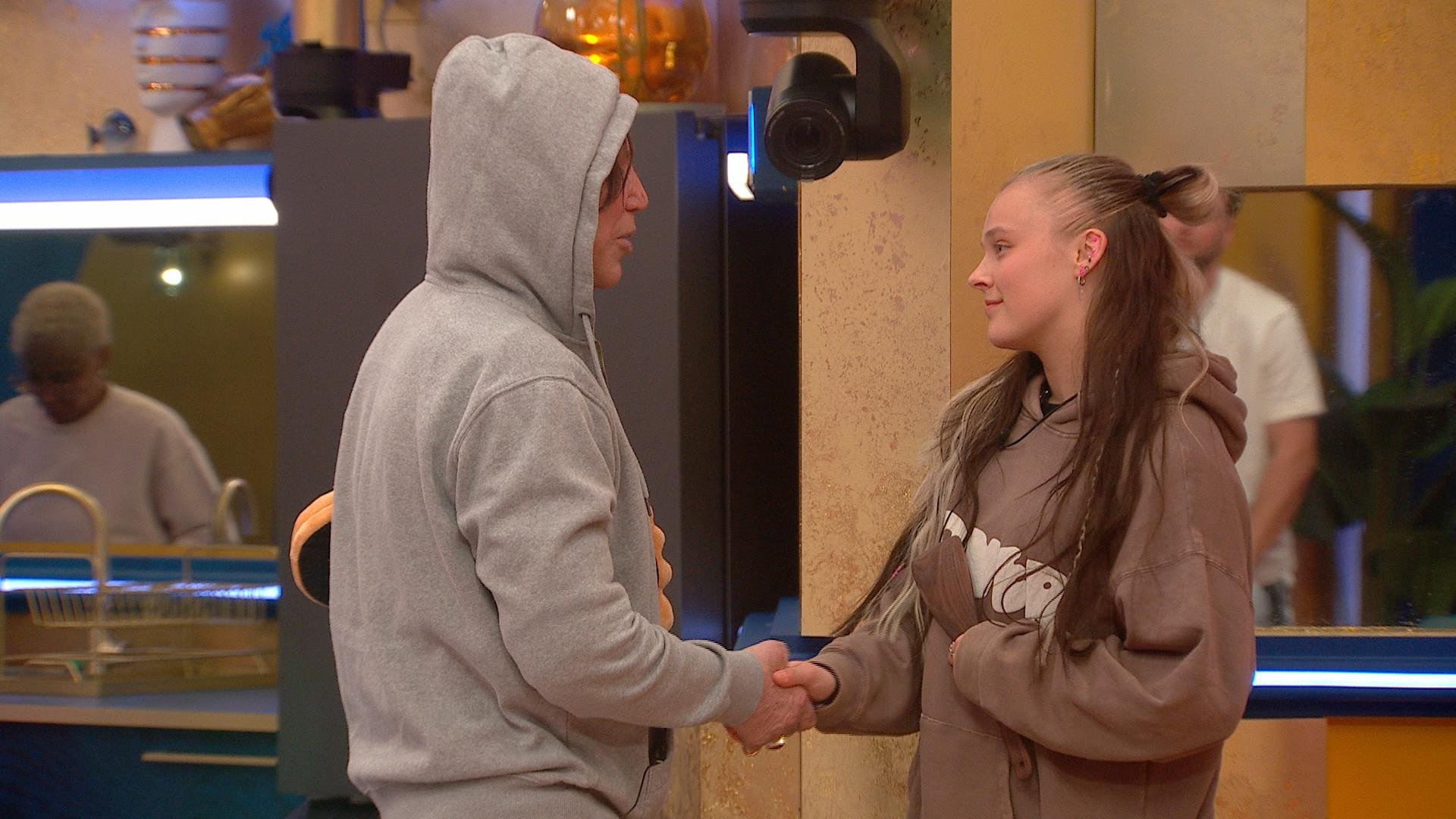Mickey Rourke and JoJo Siwa shake hands. 