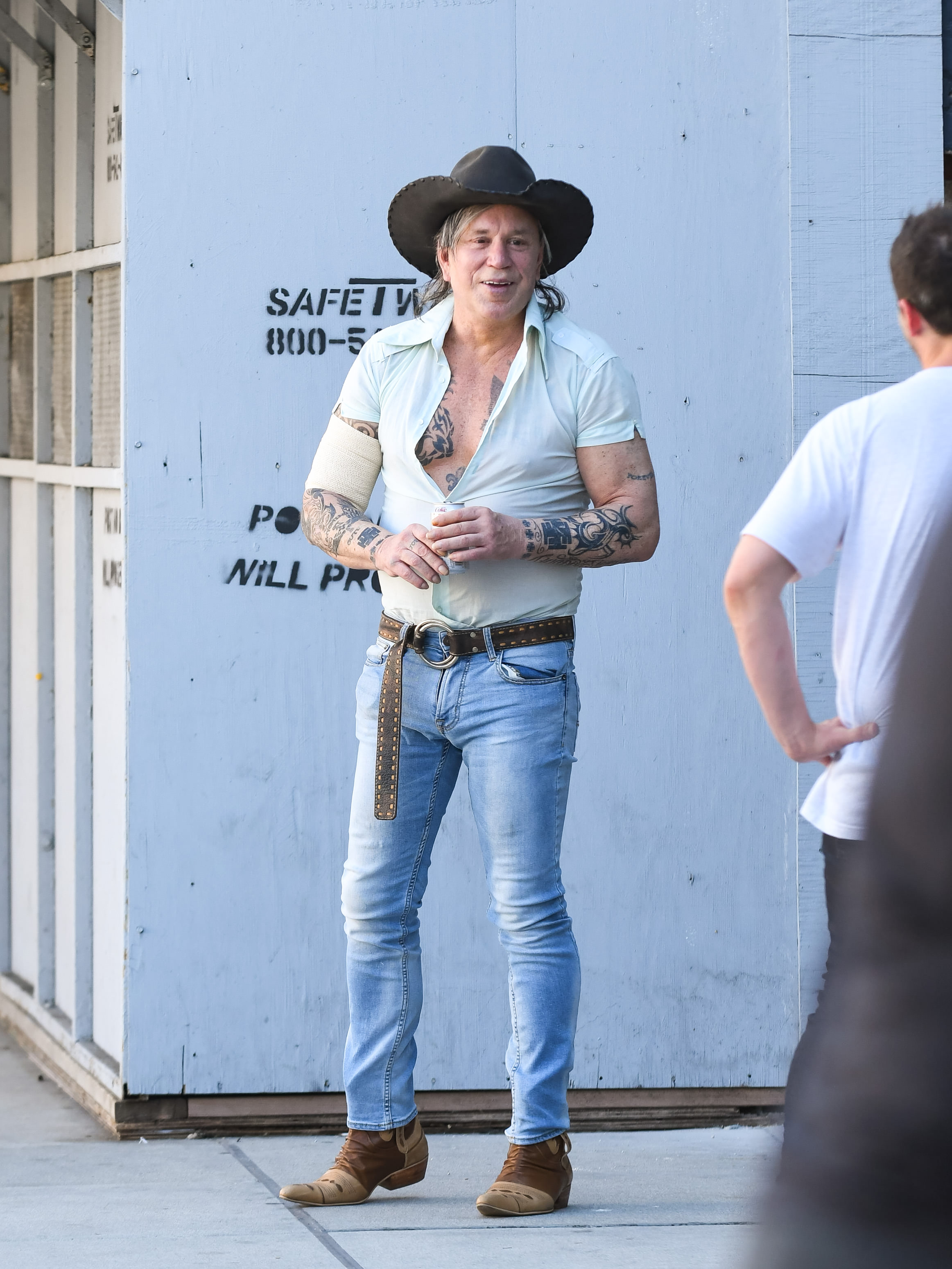Mickey Rourke in jeans and a cowboy hat. 