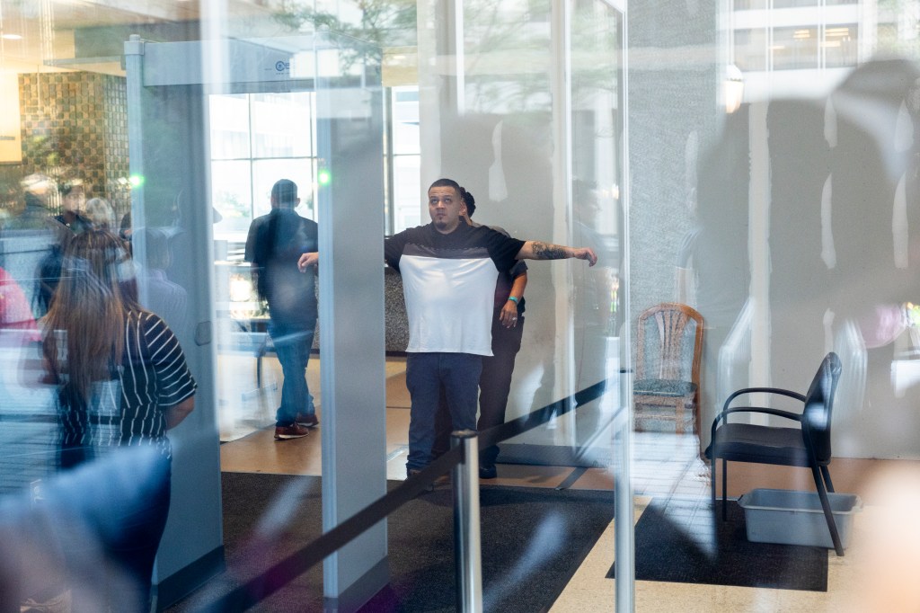 Man going through security at an ICE office.