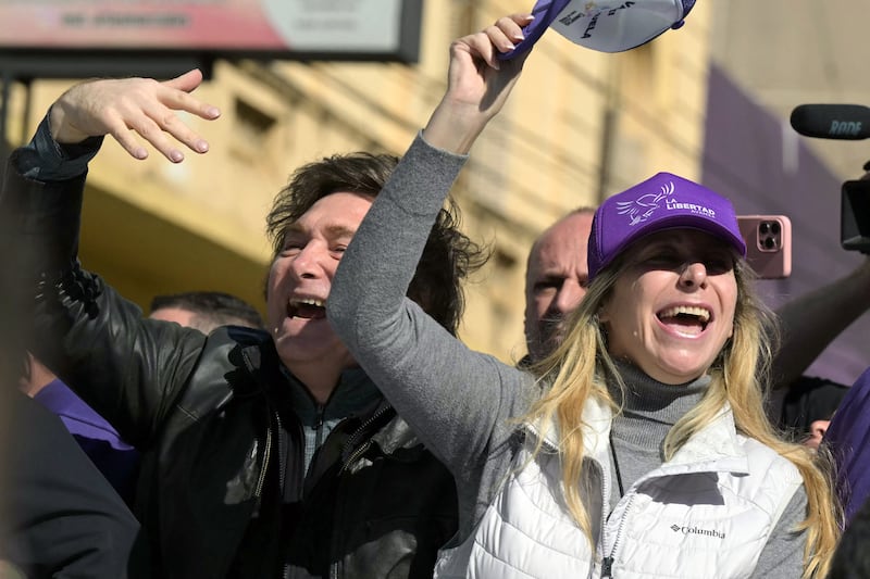Argentina's President Javier Milei (L) and his sister, Secretary General of the Presidency Karina Milei, lead a motorcade during a rally ahead of legislative provincial elections in Lomas de Zamora, Buenos Aires province, Argentina, on August 27, 2025. Argentine President Javier Milei was evacuated from a campaign event on the southern outskirts of Buenos Aires after protesters threw objects at the vehicle in which he was traveling, amid controversy over an alleged corruption case involving the government. (Photo by Juan Mabromata / AFP) (Photo by JUAN MABROMATA/AFP via Getty Images)