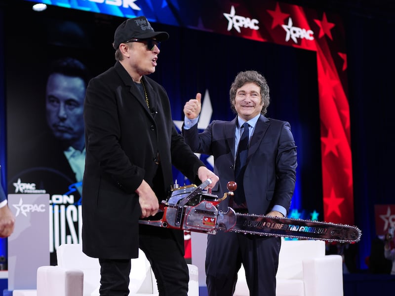 OXON HILL, MARYLAND - FEBRUARY 20: CEO of Tesla and SpaceX Elon Musk holds a chainsaw as he arrives on stage at the Conservative Political Action Conference (CPAC) at the Gaylord National Resort Hotel And Convention Center on February 20, 2025 in Oxon Hill, Maryland. The annual four-day gathering brings together conservative U.S. lawmakers, international leaders, media personalities and businessmen to discuss and champion conservative ideas. Musk was joined on stage by Argentine President Javier Milei, who gifted Musk the chainsaw he used as a prop while campaigning. (Photo by Andrew Harnik/Getty Images)