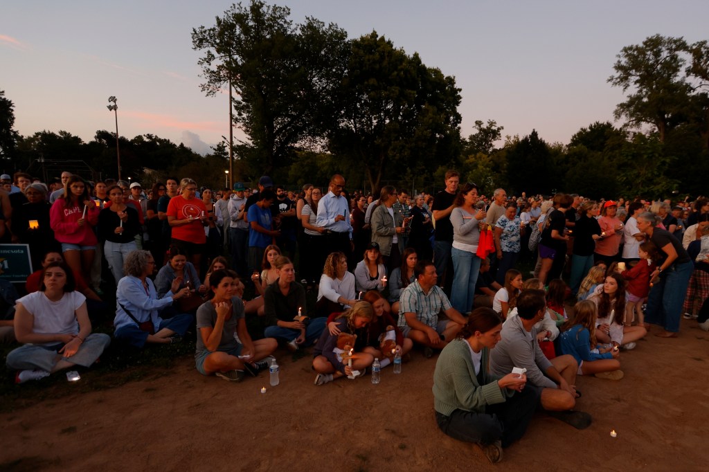 People holding candles at a vigil.