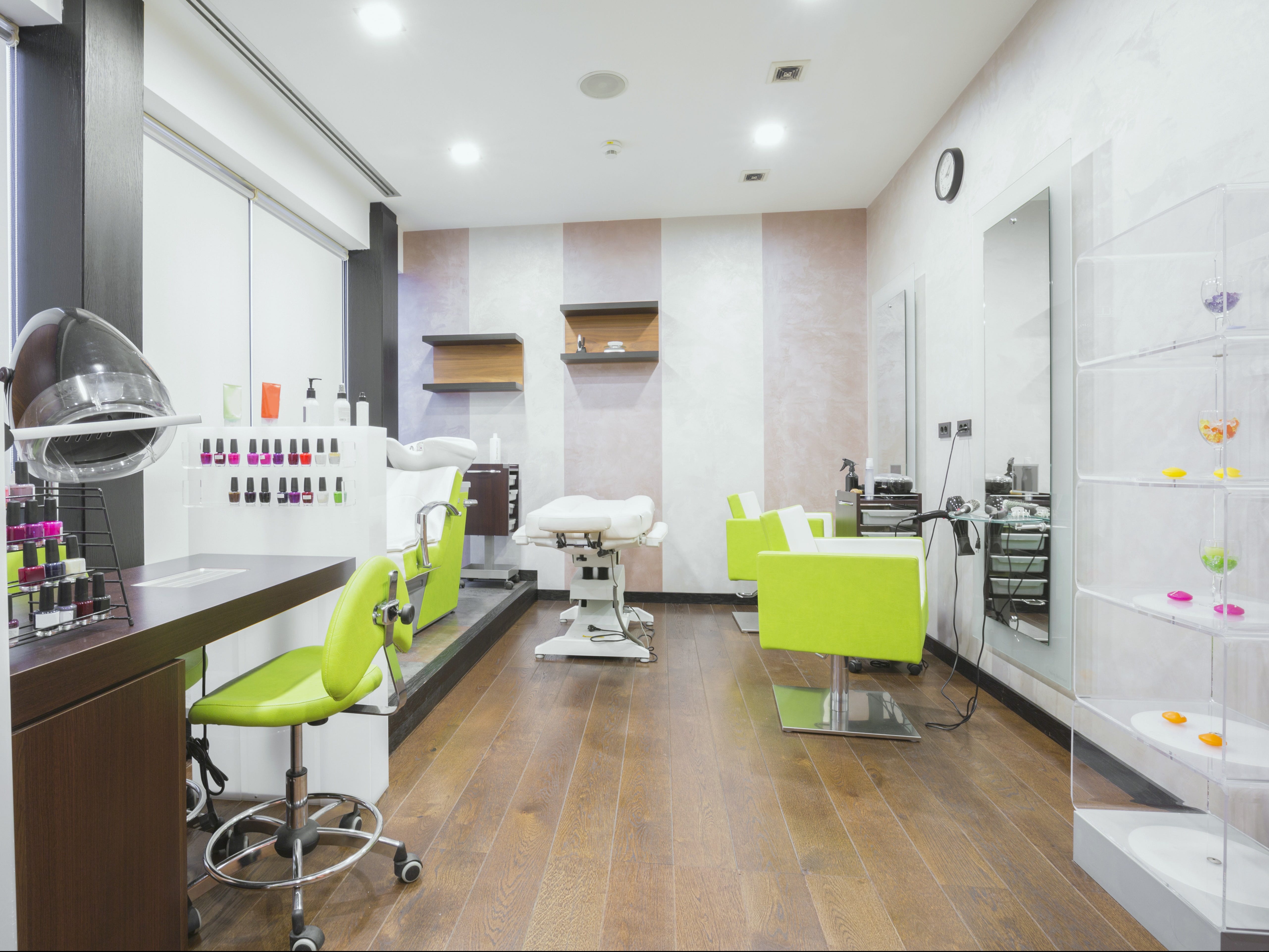 A spa with neon green chairs and various nail polish bottles.