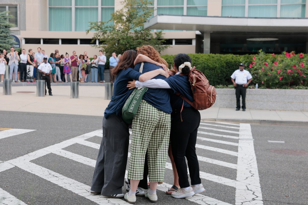 State Department employees hugging after layoffs.