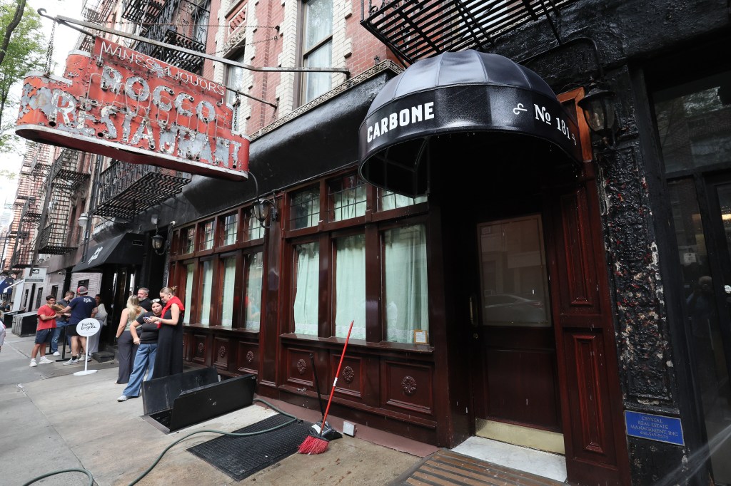Exterior of Carbone restaurant in New York City with people waiting in line.