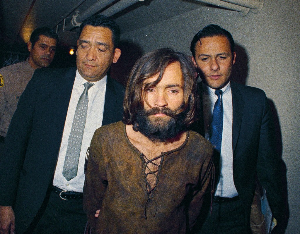 Charles Manson escorted by guards.