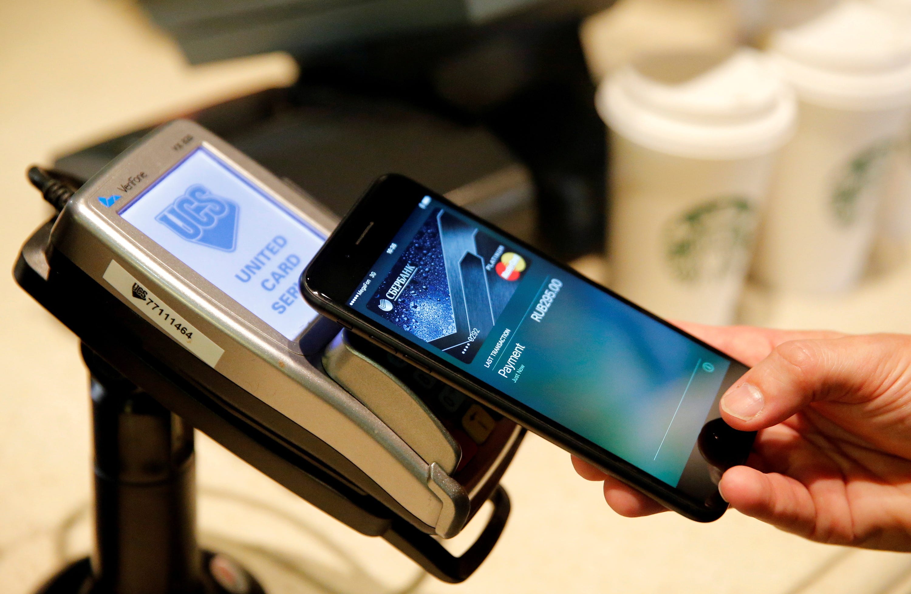 A person uses Apple Pay on an iPhone in a Moscow cafe.