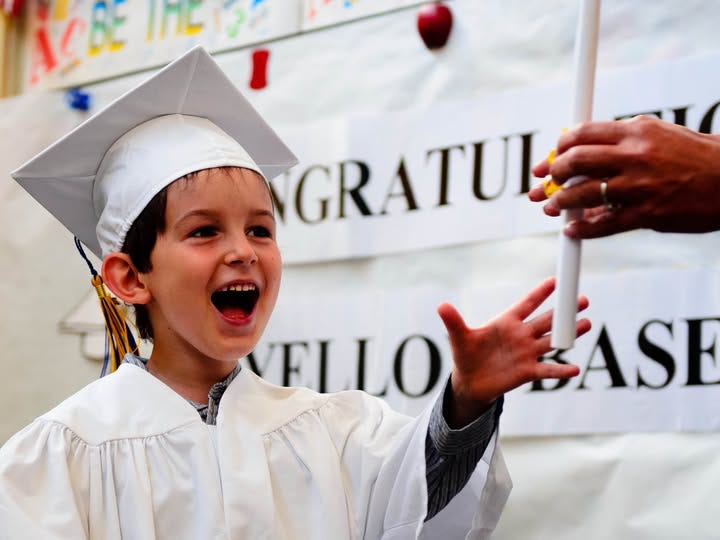 The author's son wearing a graduation cap and gown and smiling.