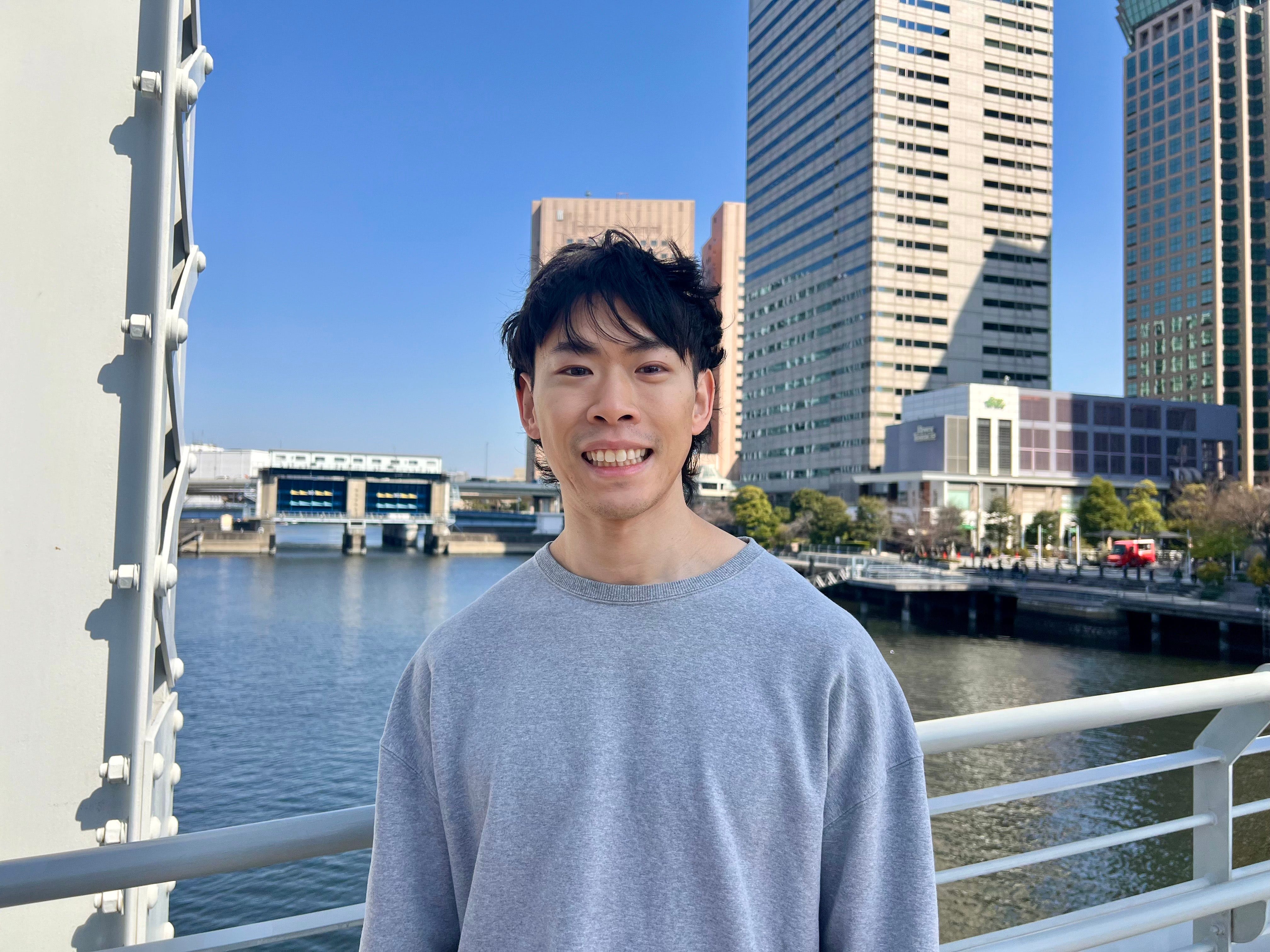 Jim Tang standing outdoors in front of a tower block.