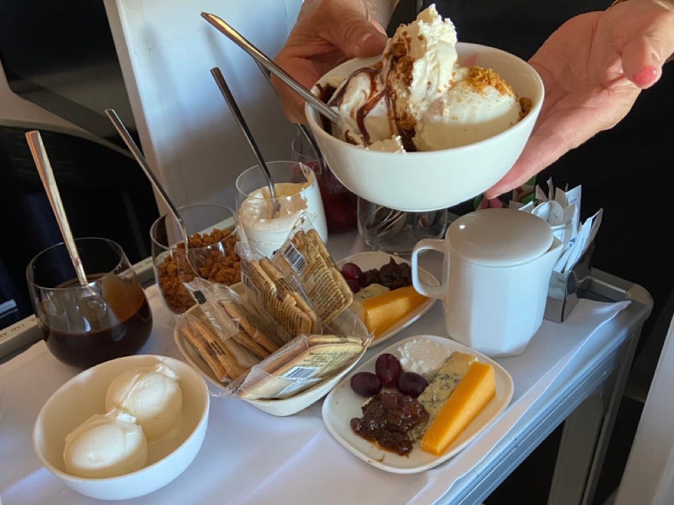 Ice cream being placed on tray table with other snacks, drinks