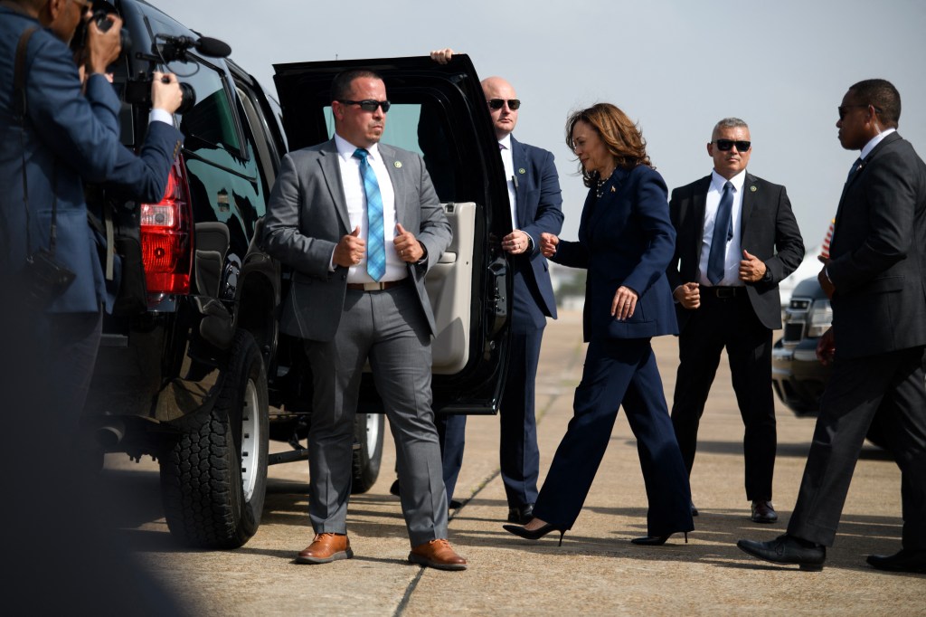 Kamala Harris exiting a vehicle with Secret Service agents.