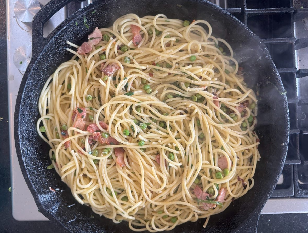 The pasta cooking with pancetta and peas.
