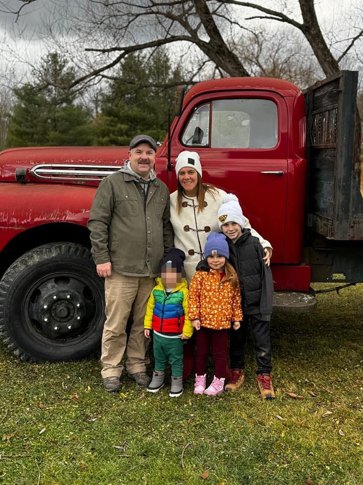 Family photo in front of a red truck.