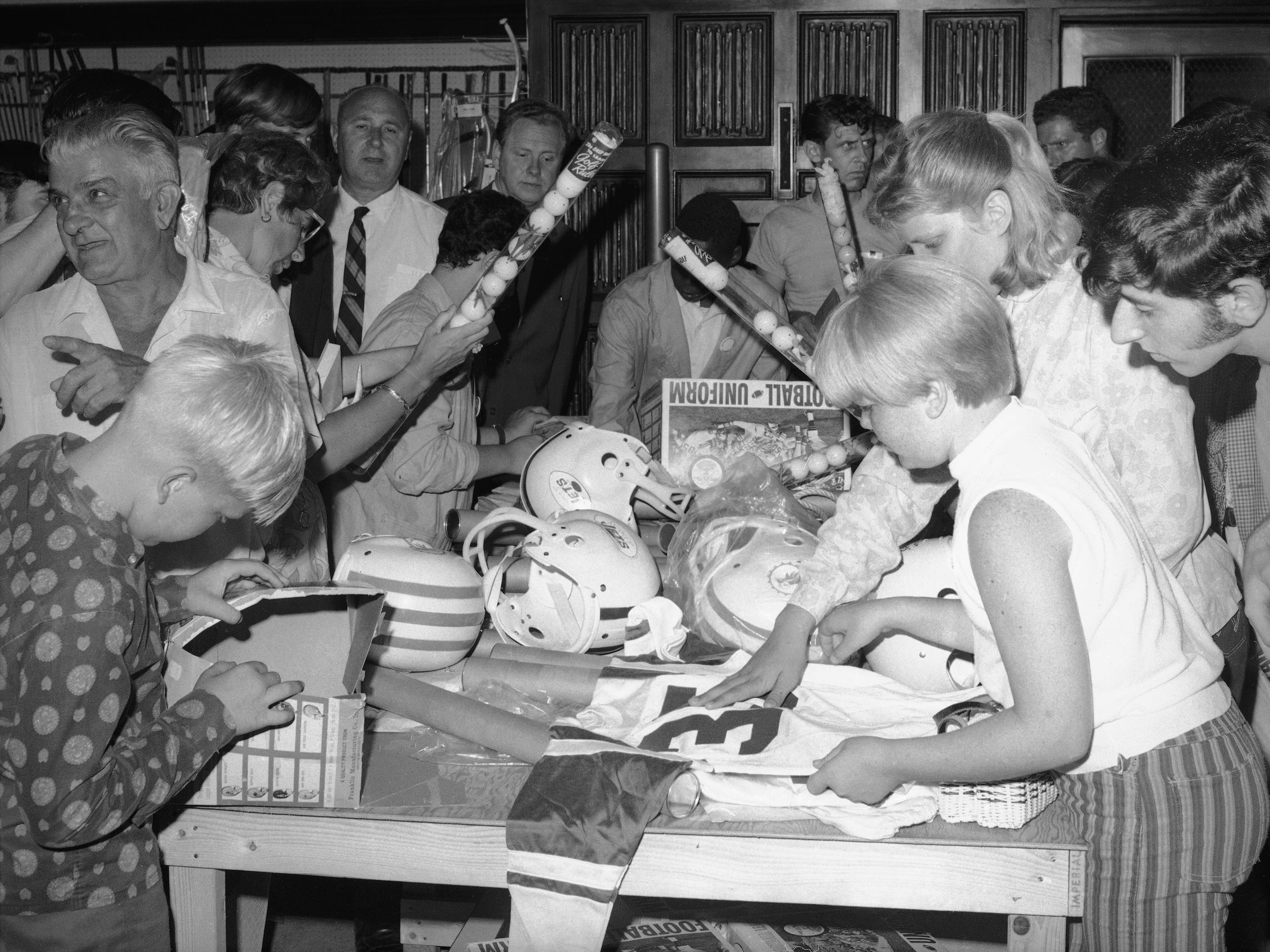 Crowd of people shops sporting goods sale at Abercrombie & Fitch in the 1960s