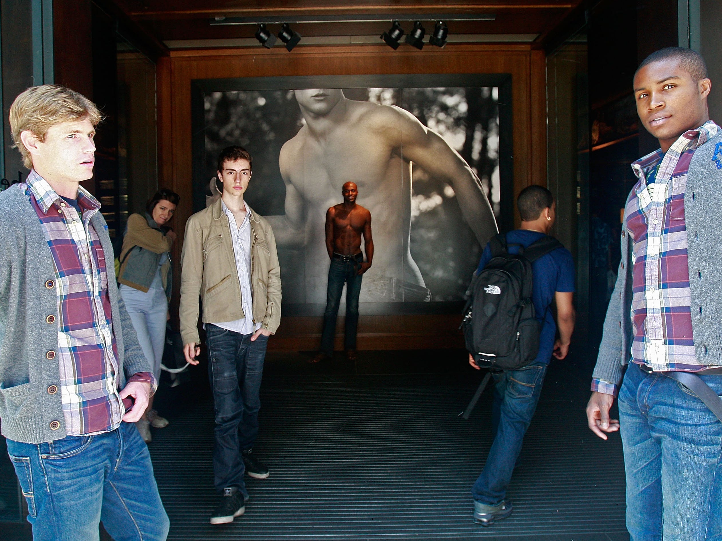Two male models hold doors at entrance to Abercrombie & Fitch store