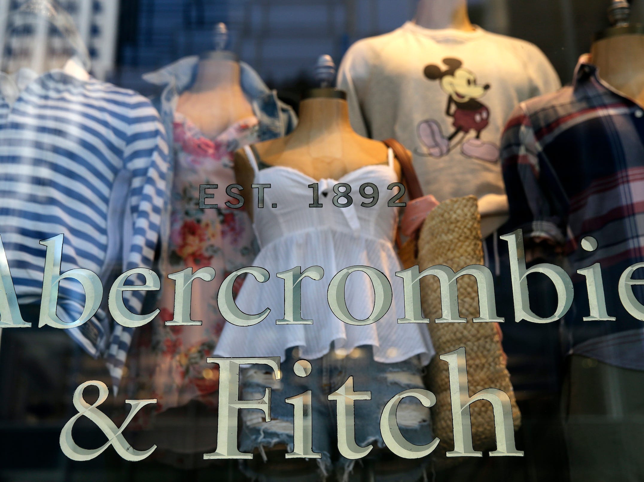 Mannequins wearing summer clothes are visible inside window of Abercrombie & Fitch store