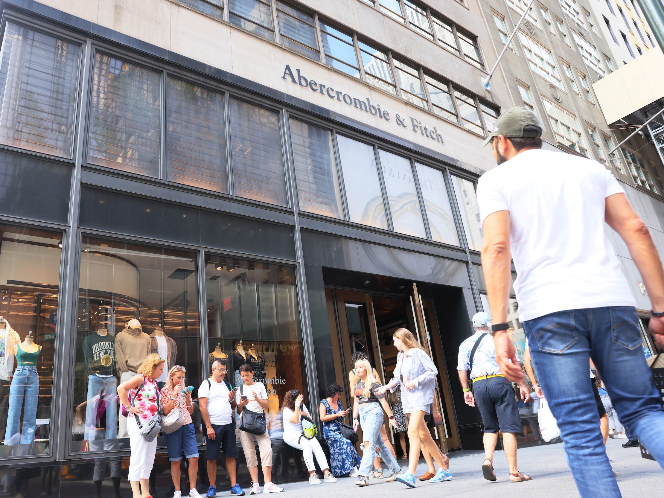Shoppers stand outside Abercrombie store as man walks toward entrance