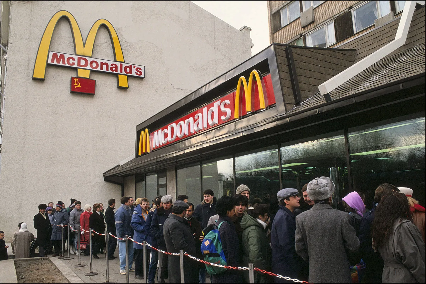A line of people outside a McDonald's fast food restaruant.
