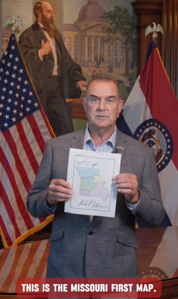Missouri governor holding a proposed congressional district map.
