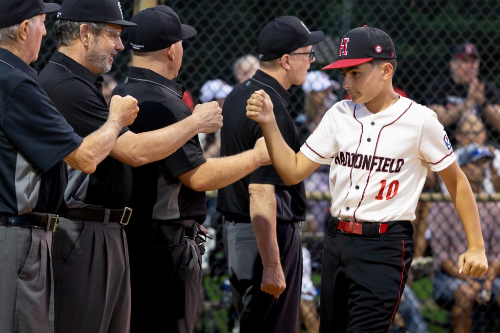 Marco Rocco bumps fists with the umpires during player introductions before the start of the game. 