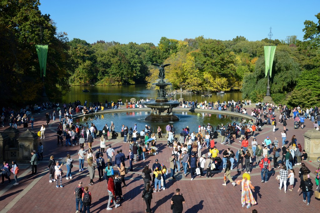 Bethesda Fountain in Central Park surrounded by people.