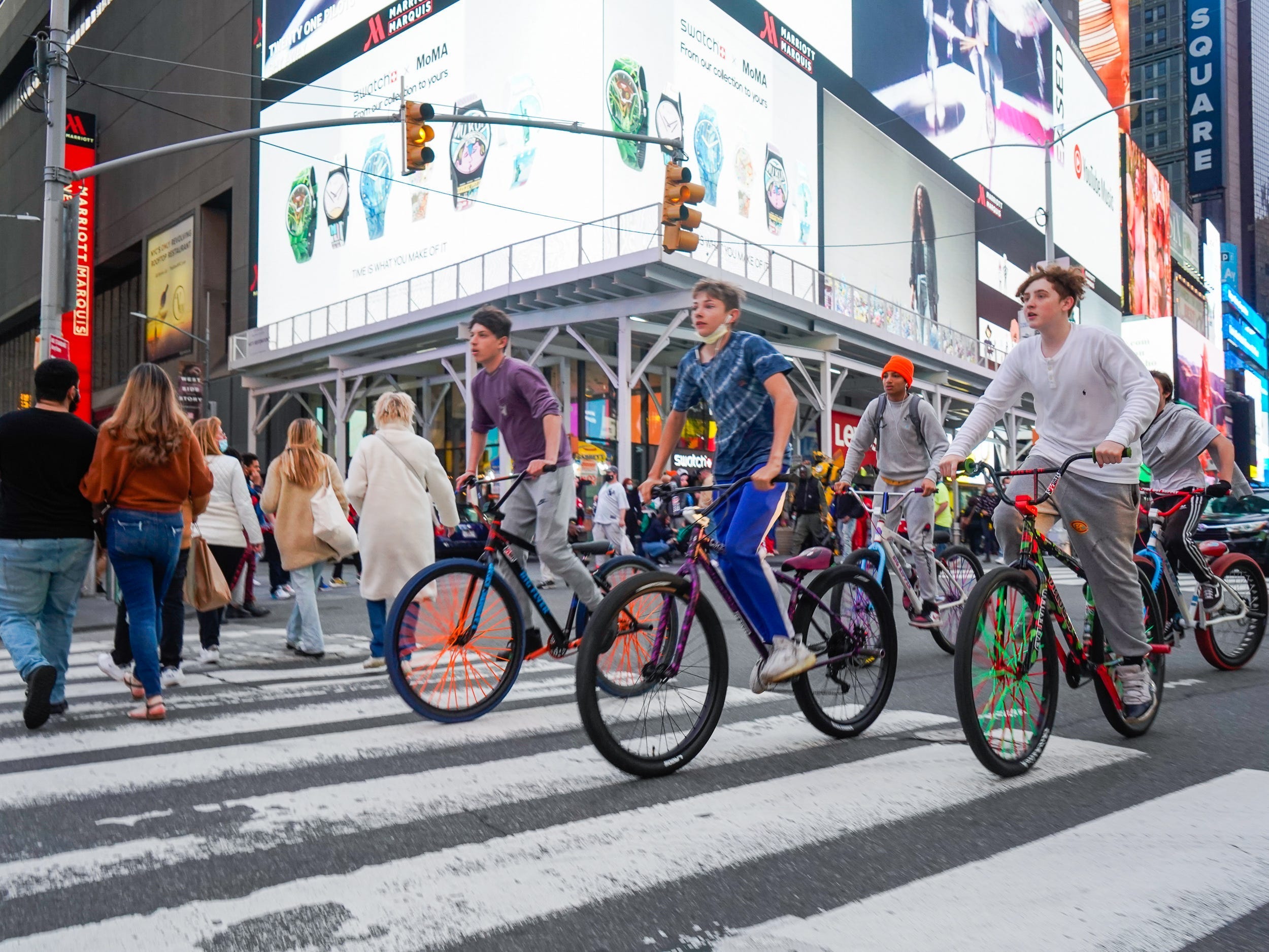 Cyclists ride on a busy intersection in Times Square