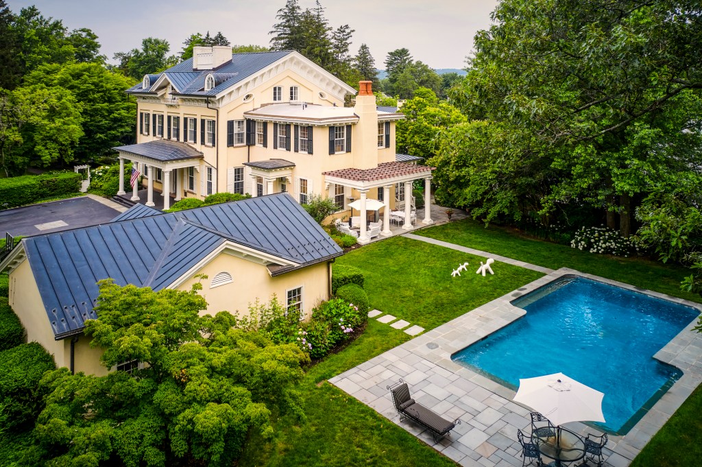 Aerial view of a Georgian mansion with pool and landscaping.