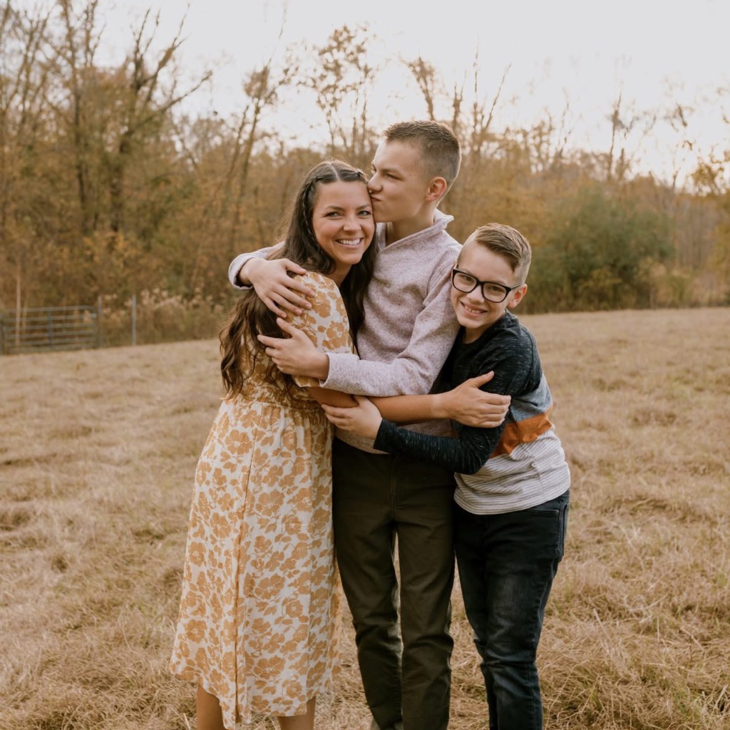 A woman hugs her two sons.
