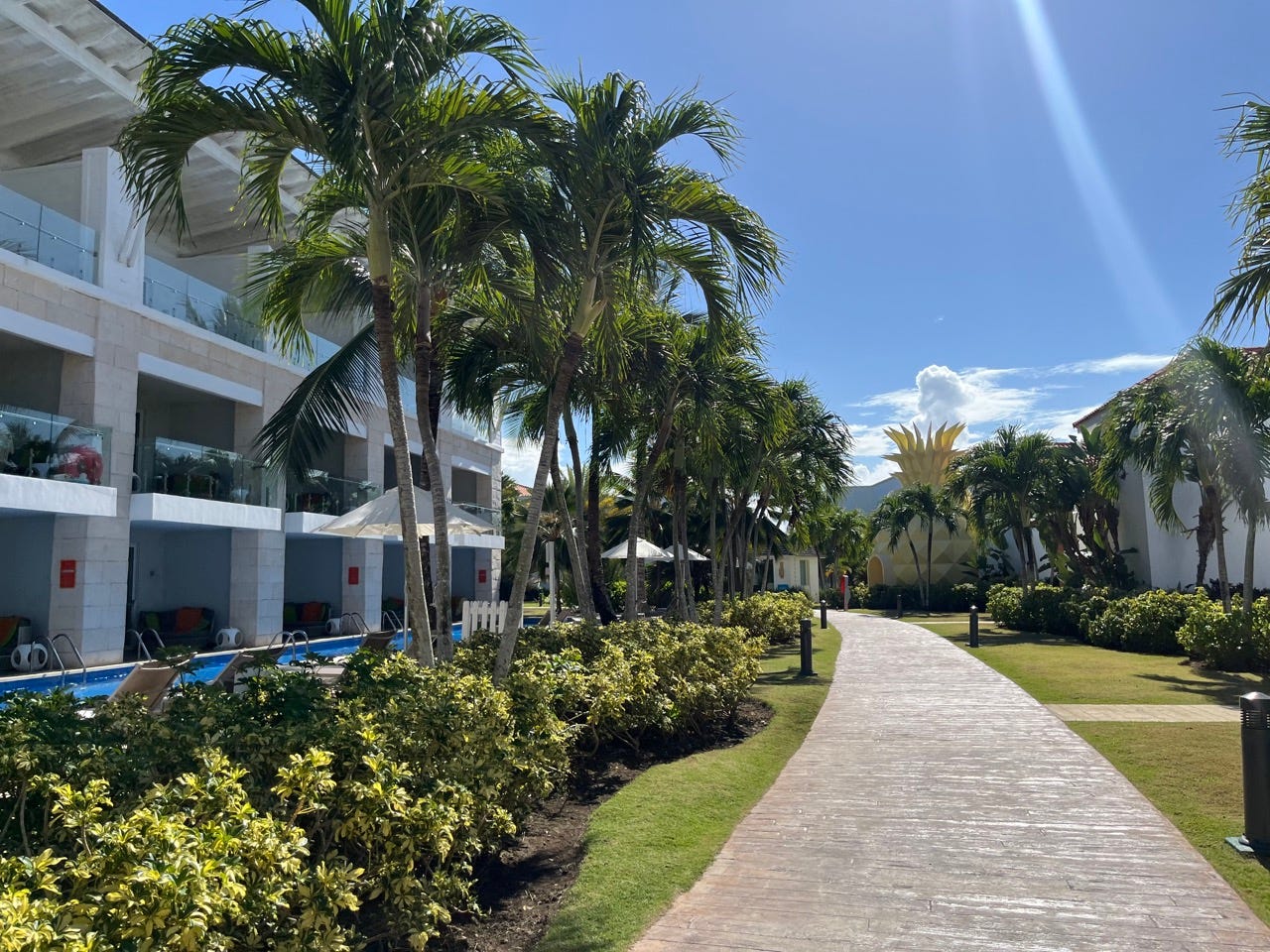Nickelodean resort with white exterior, palm-tree-lined pathway