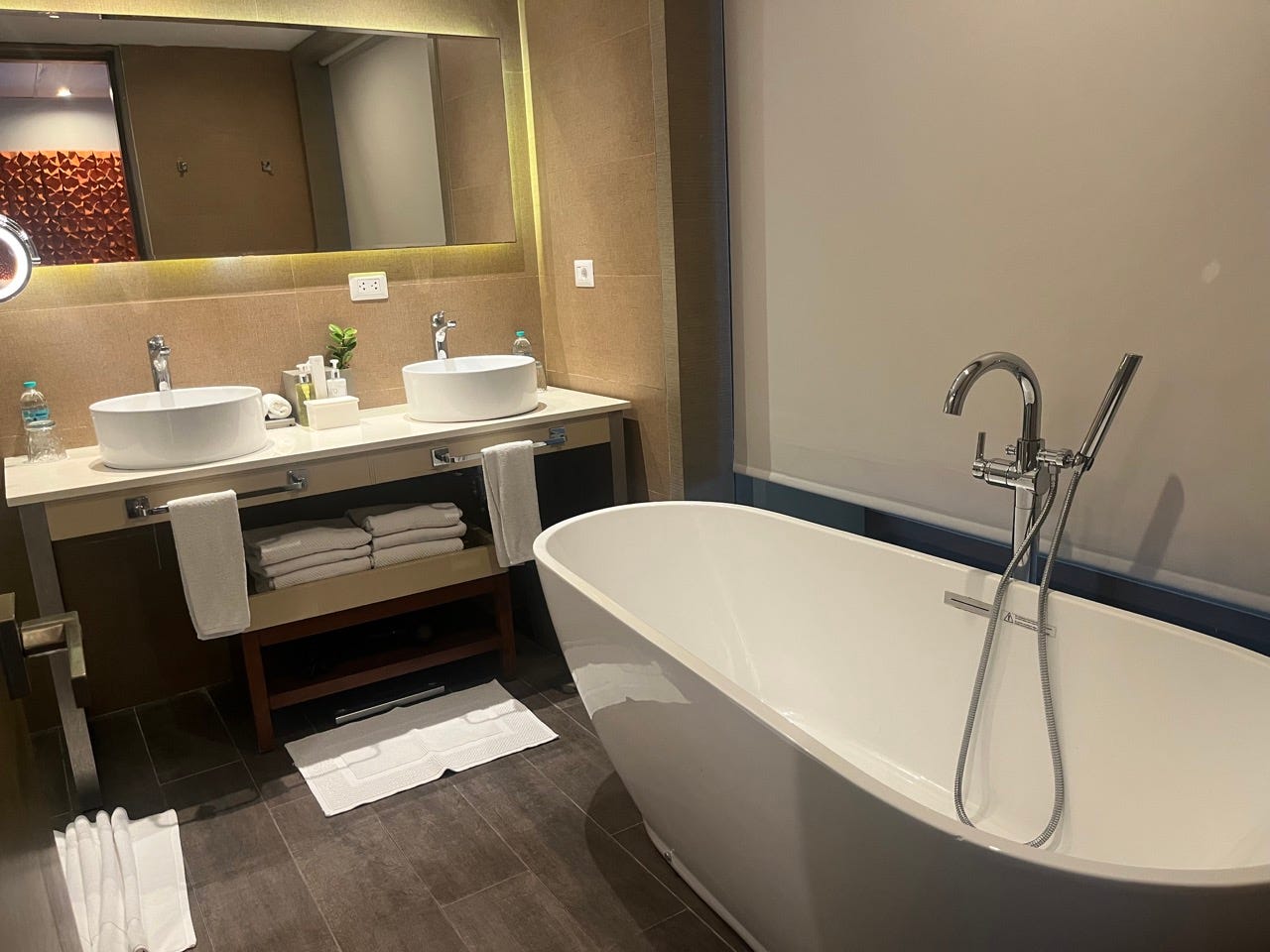 Bathroom with large standalone tub, double vanity, backlit mirror