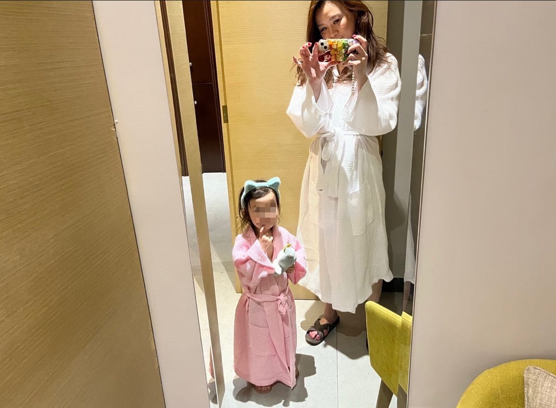 Author Tiffany Leigh and child taking selfie in robes at spa