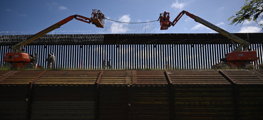 U.S. troops install concertina wire on top of the wall along the U.S.-Mexico border near the San Ysidro Port of Entry in San Diego, California, April 23, 2025. 