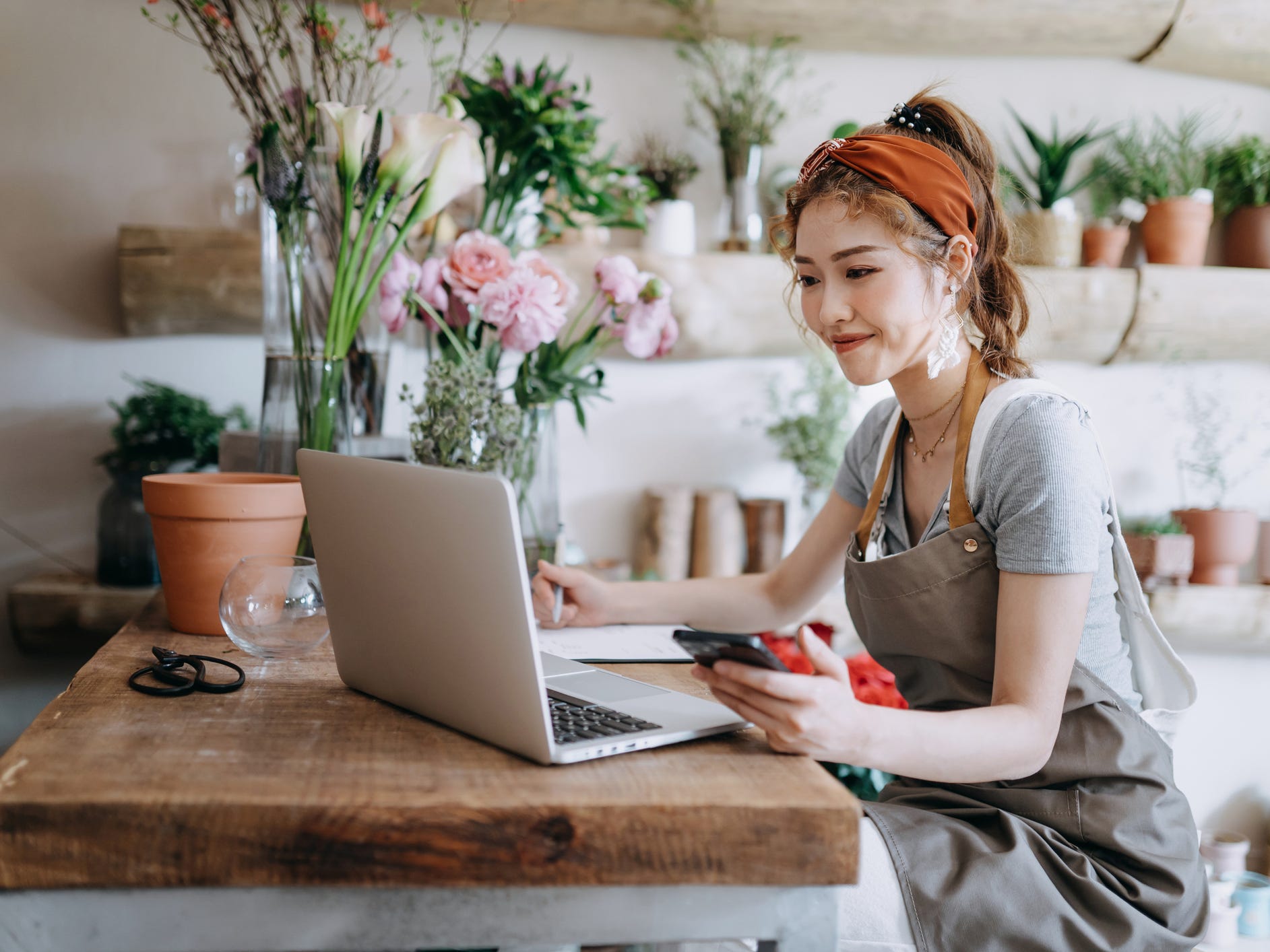 small business owner uses computer while working in florist shop