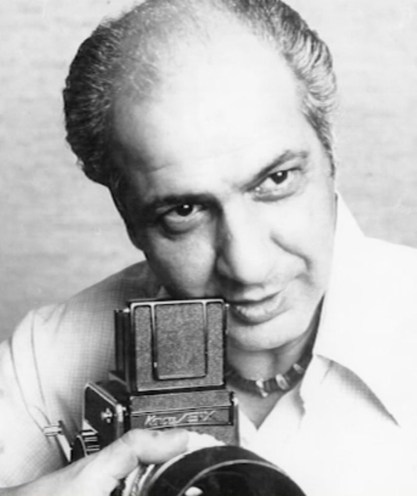 Black and white photo of Joseph Naso holding a camera.