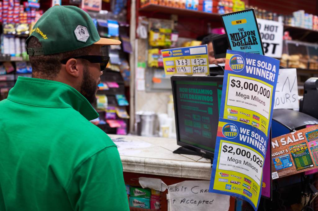 A customer at Esam Deli reading signs about recent Powerball winning tickets sold at the market.