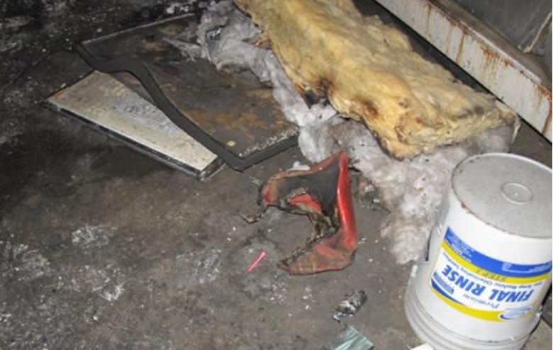 Fire damage debris including charred insulation and a bucket.