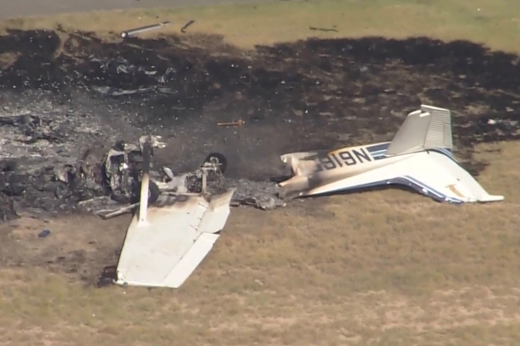 Burned plane wreckage on the ground.