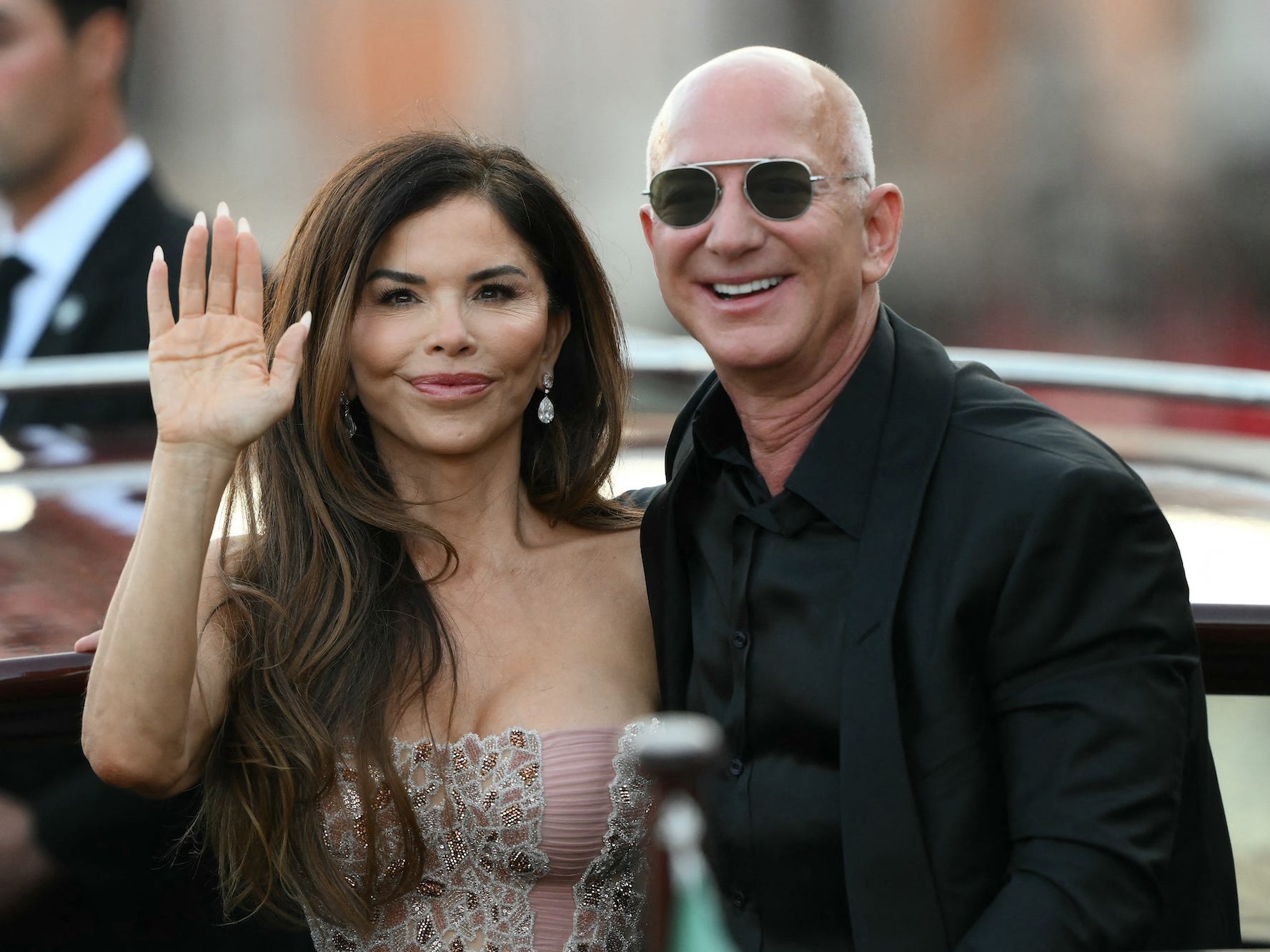 Lauren Sánchez and Jeff Bezos on a boat in Venice. Sánchez waves at the public.