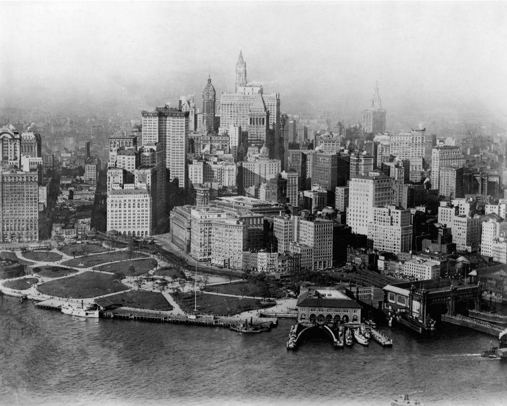 Several tall buildings in lower Manhattan, surrounded by water