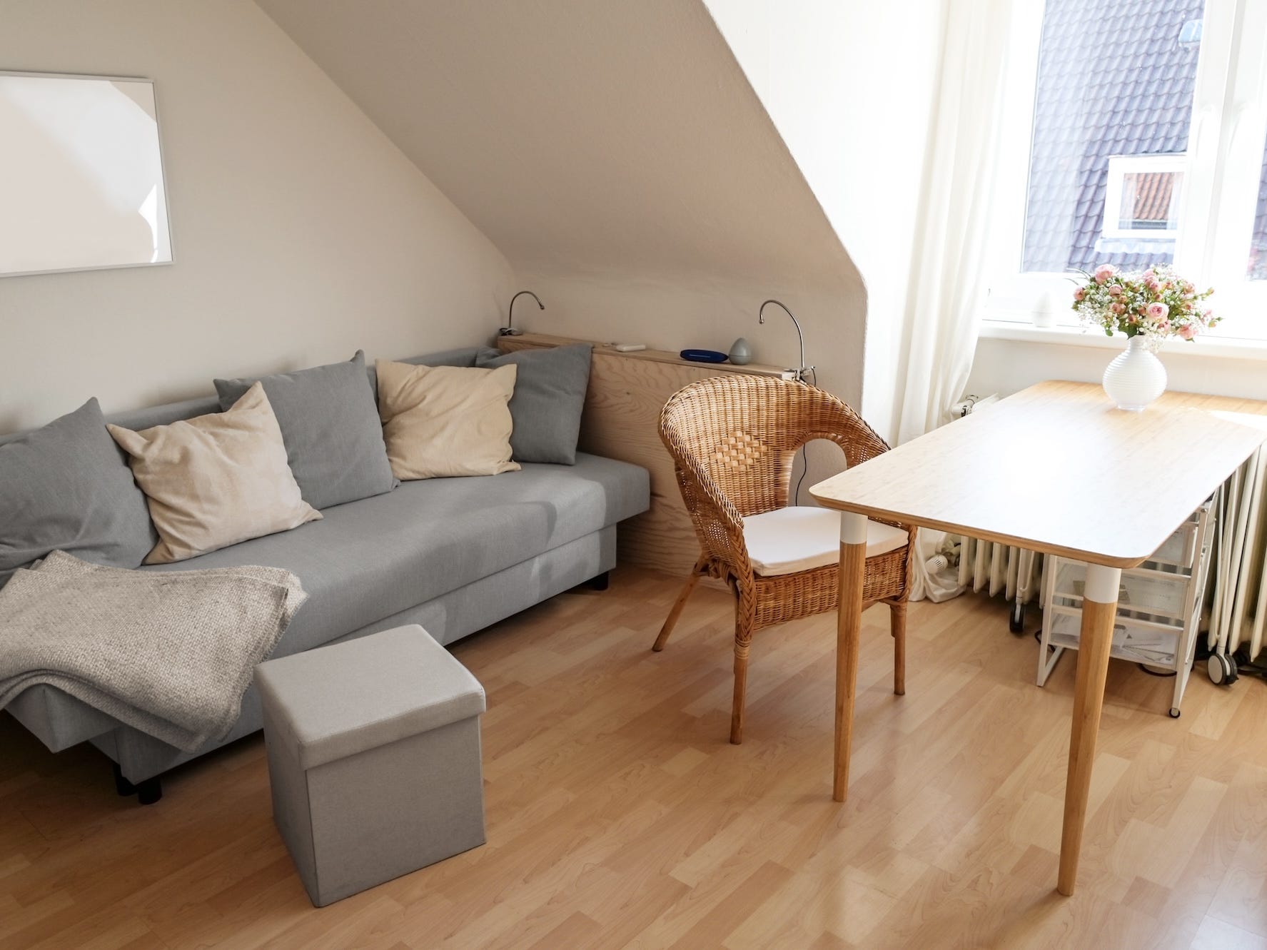 A small living area with a couch, side table, dining table, and cahirs.