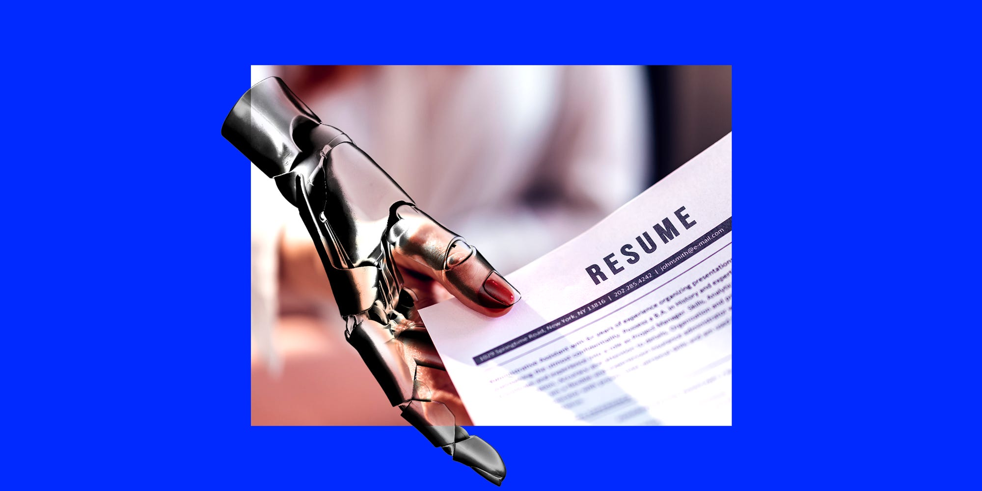 A robot hand holding a résumé.