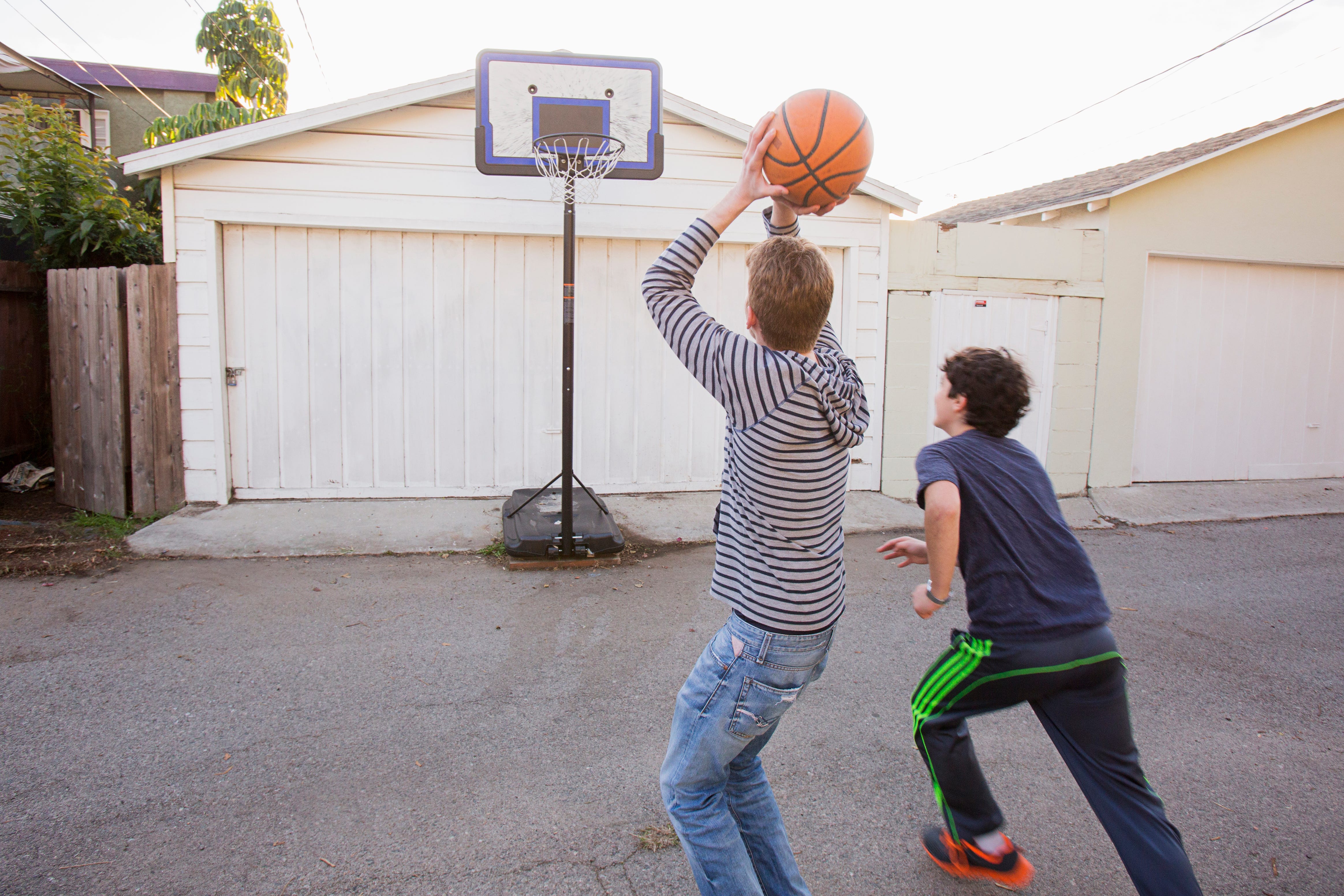 Two teenage brothers play basketball