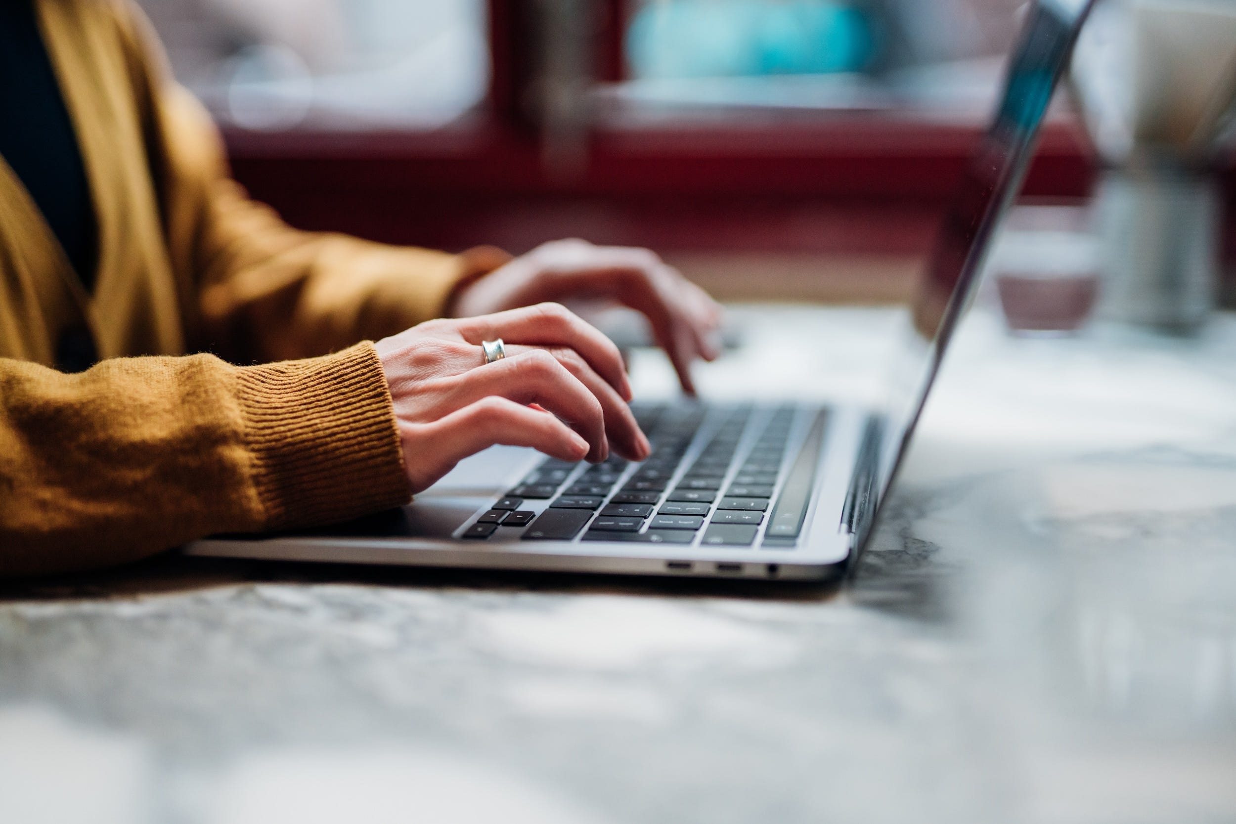 A close-up of someone's fingers typing on a laptop.