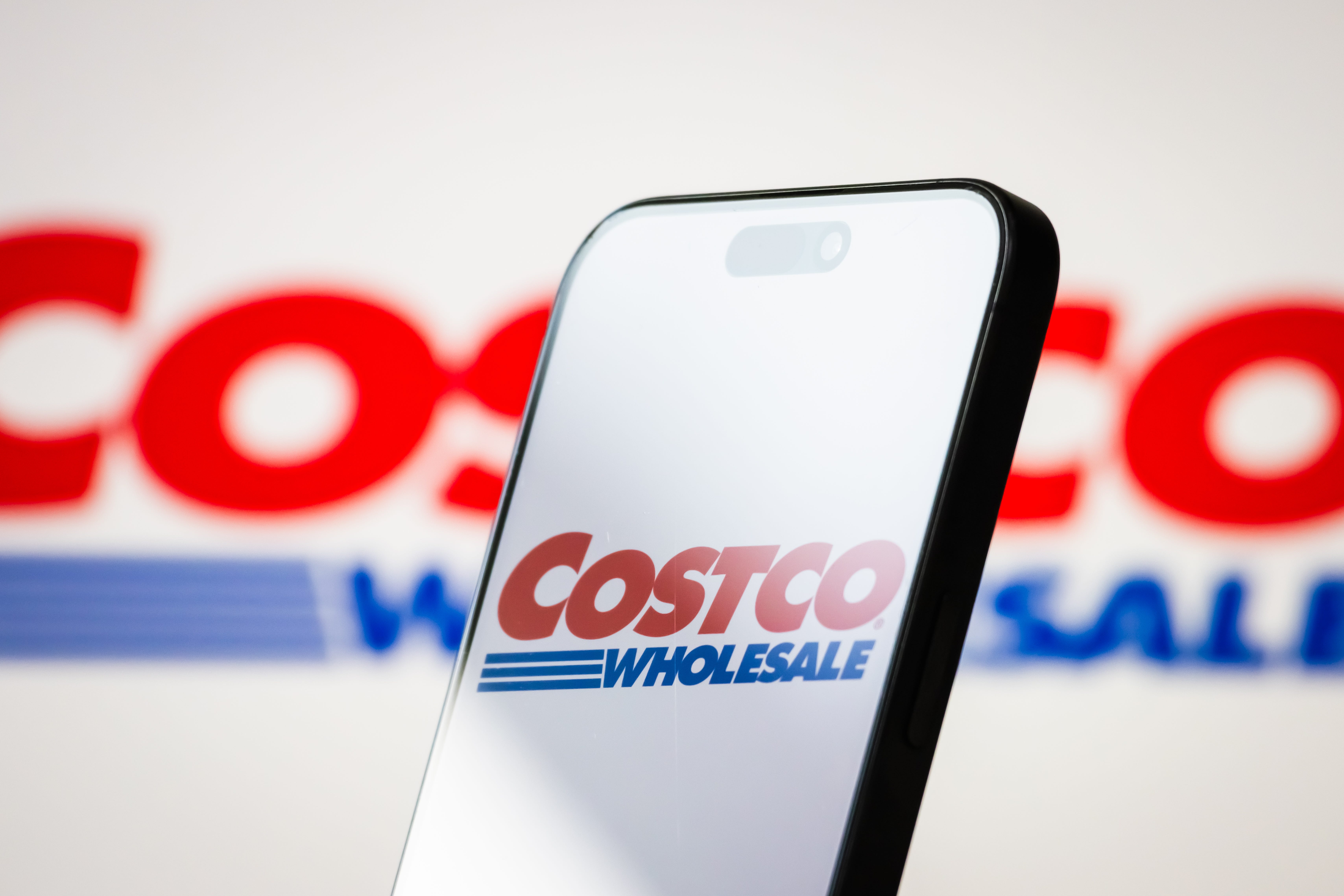 The logo of Costco Wholesale is displayed on a smartphone screen.