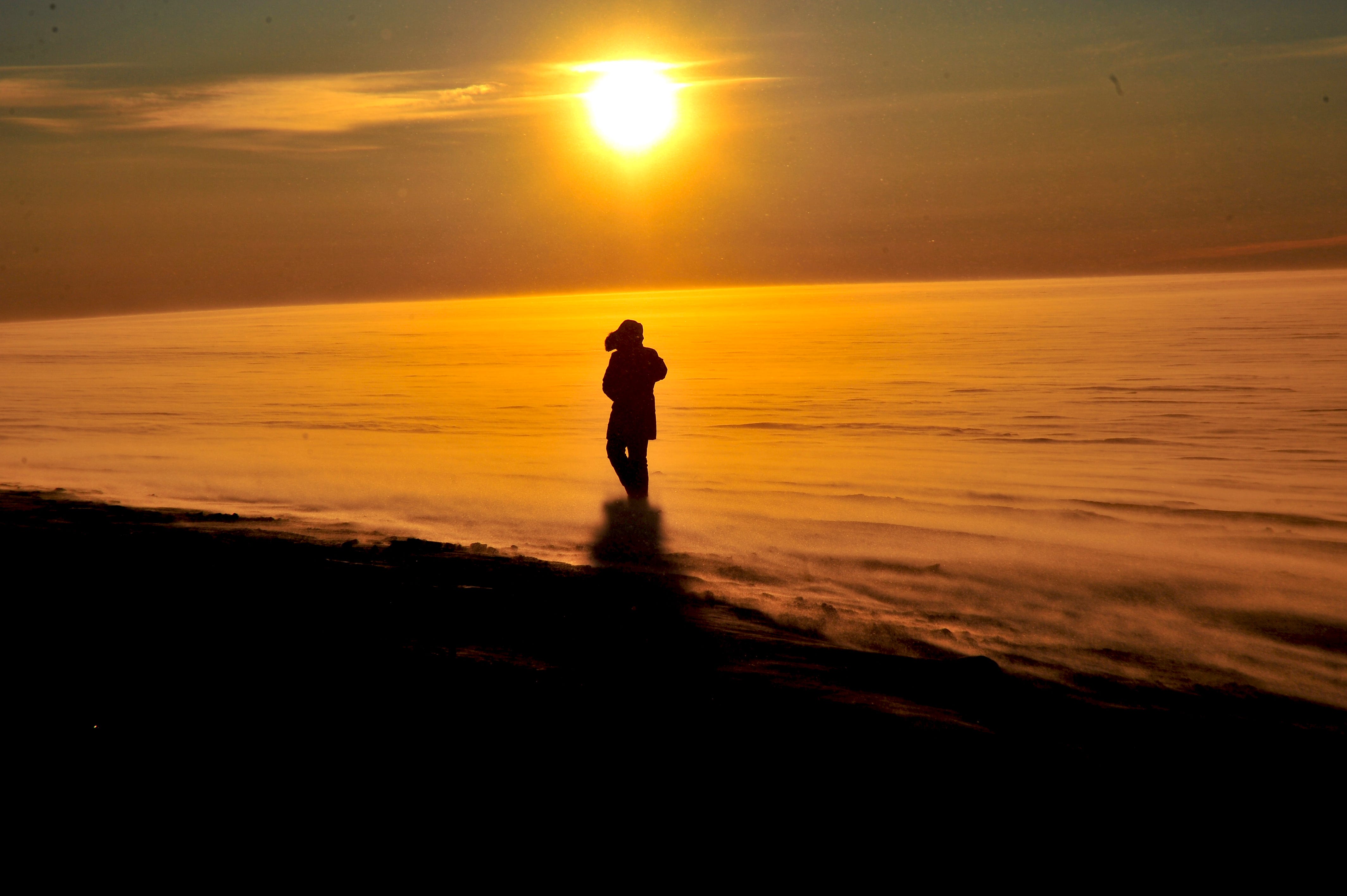 A man walks along a snowy surface.