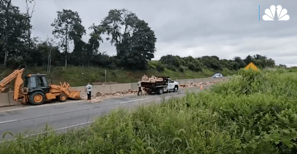 Crews cleaning up bricks scattered on a highway.