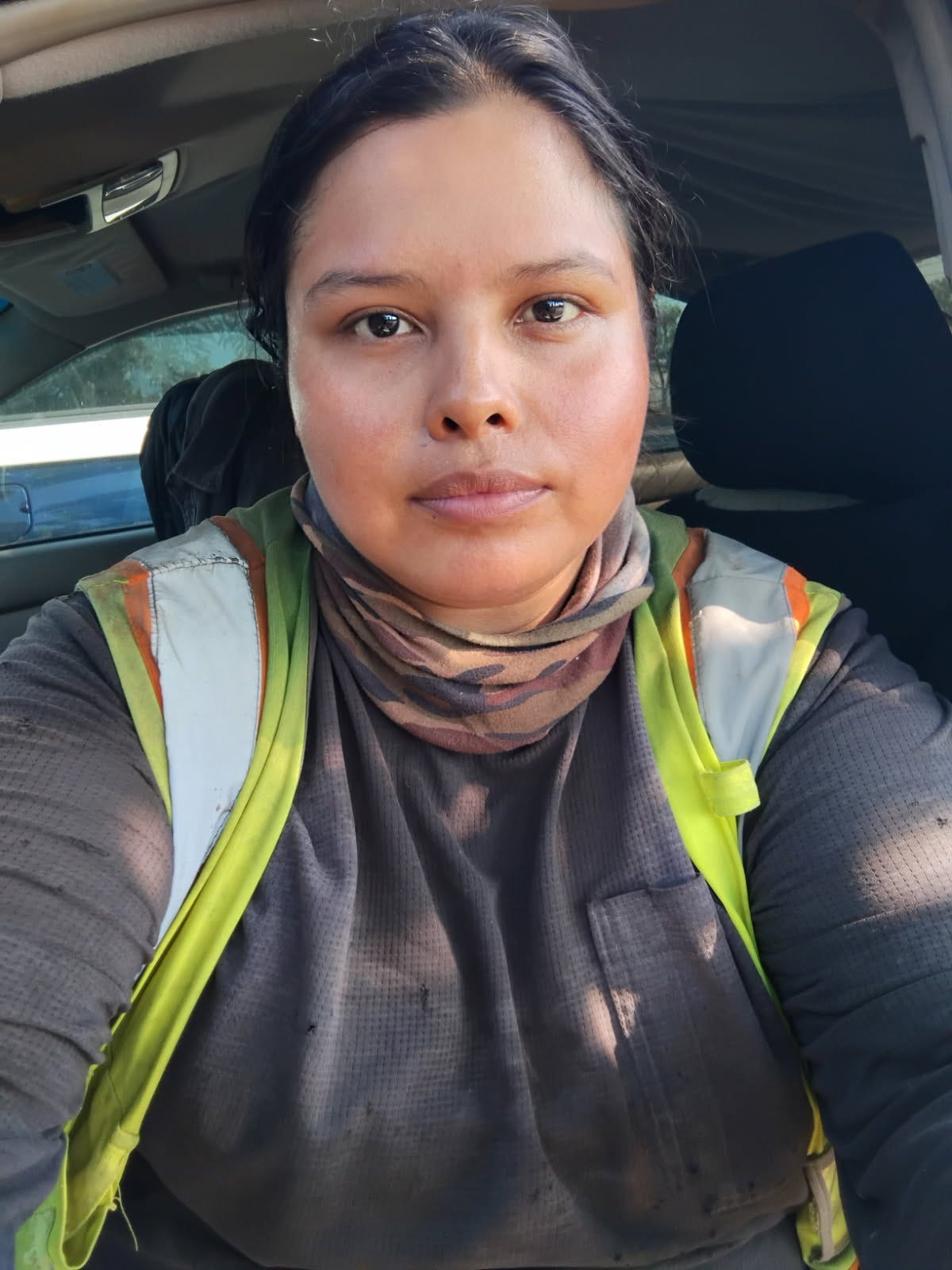 A woman in construction gear takes a selfie