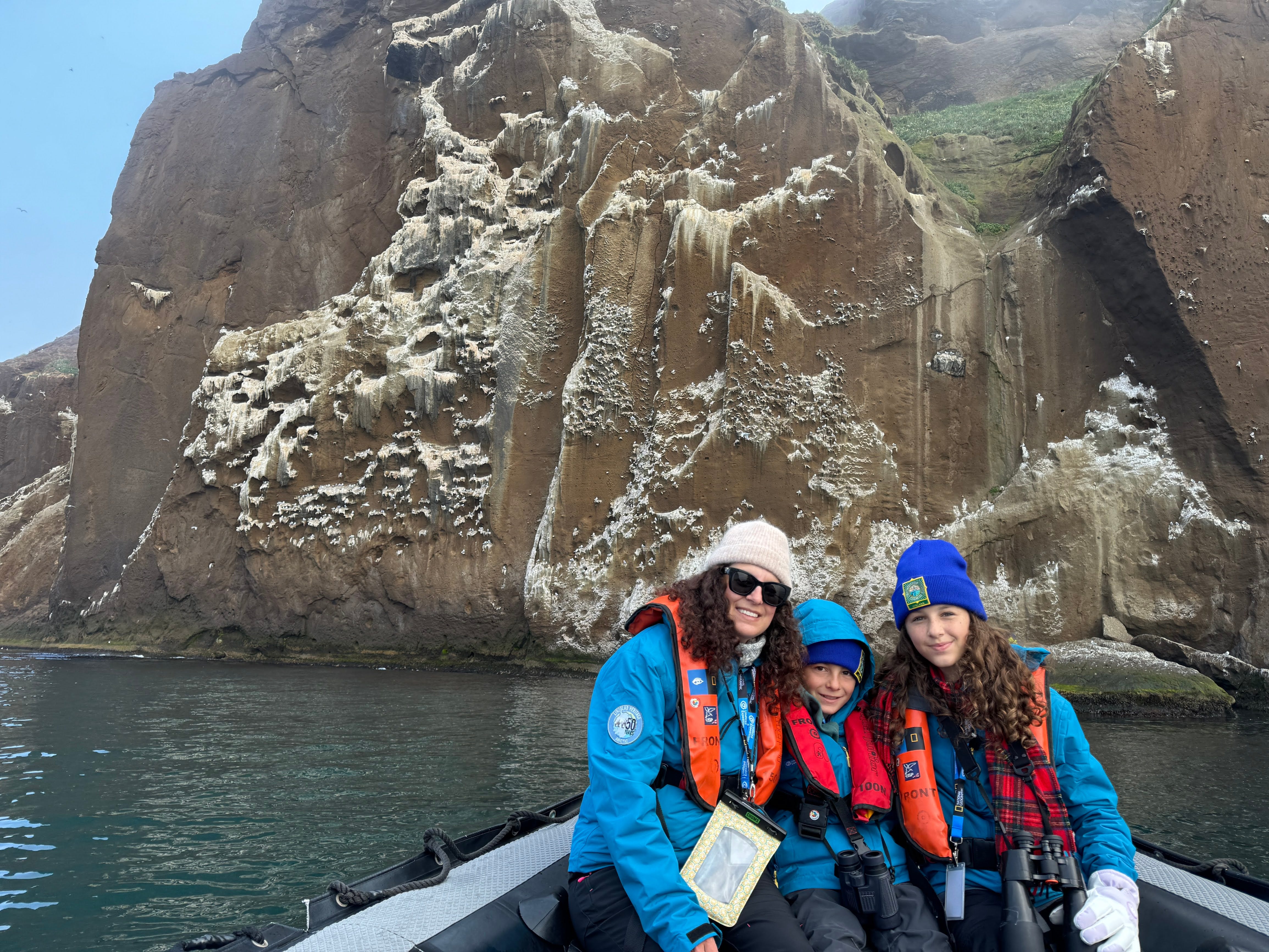 jamie and her kids on a small boat exploring a site on an expedition cruise to iceland
